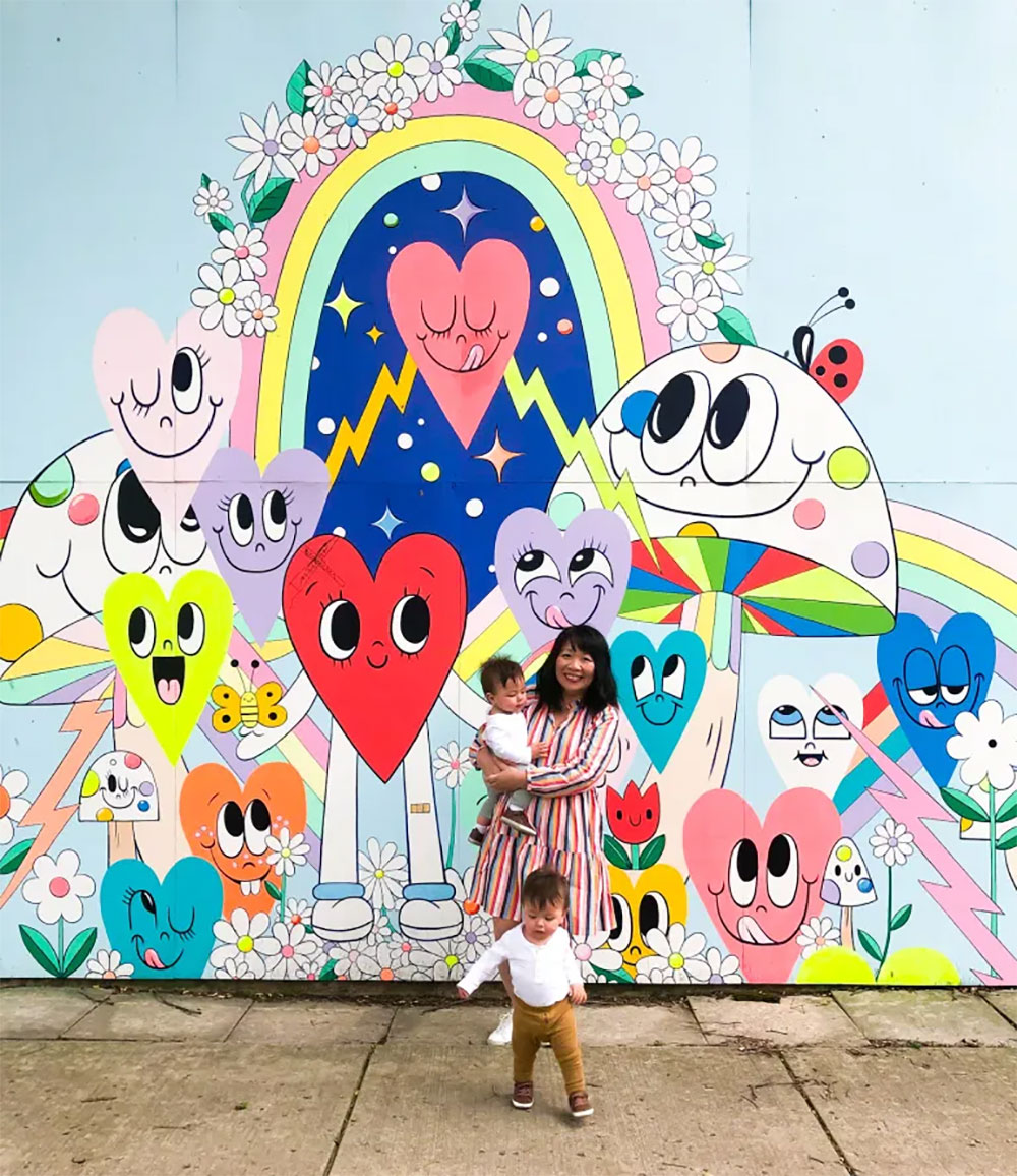 A mother poses with her children in front of Chris Uphues' Happy Garage mural along Ravenswood Ave