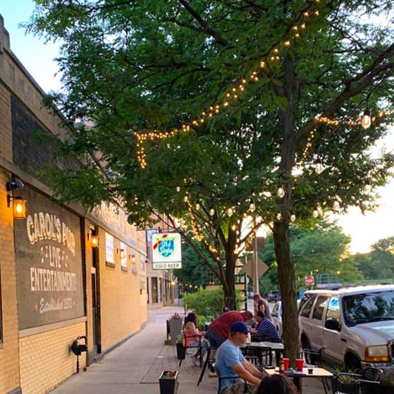 An evening on the patio at Carol's Pub with a classic Old Style sign in the background