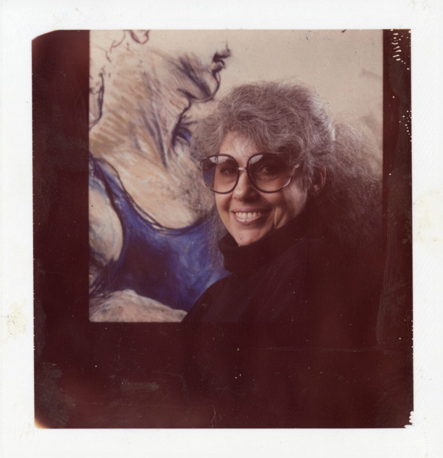 Judith Roth smiling with her artwork