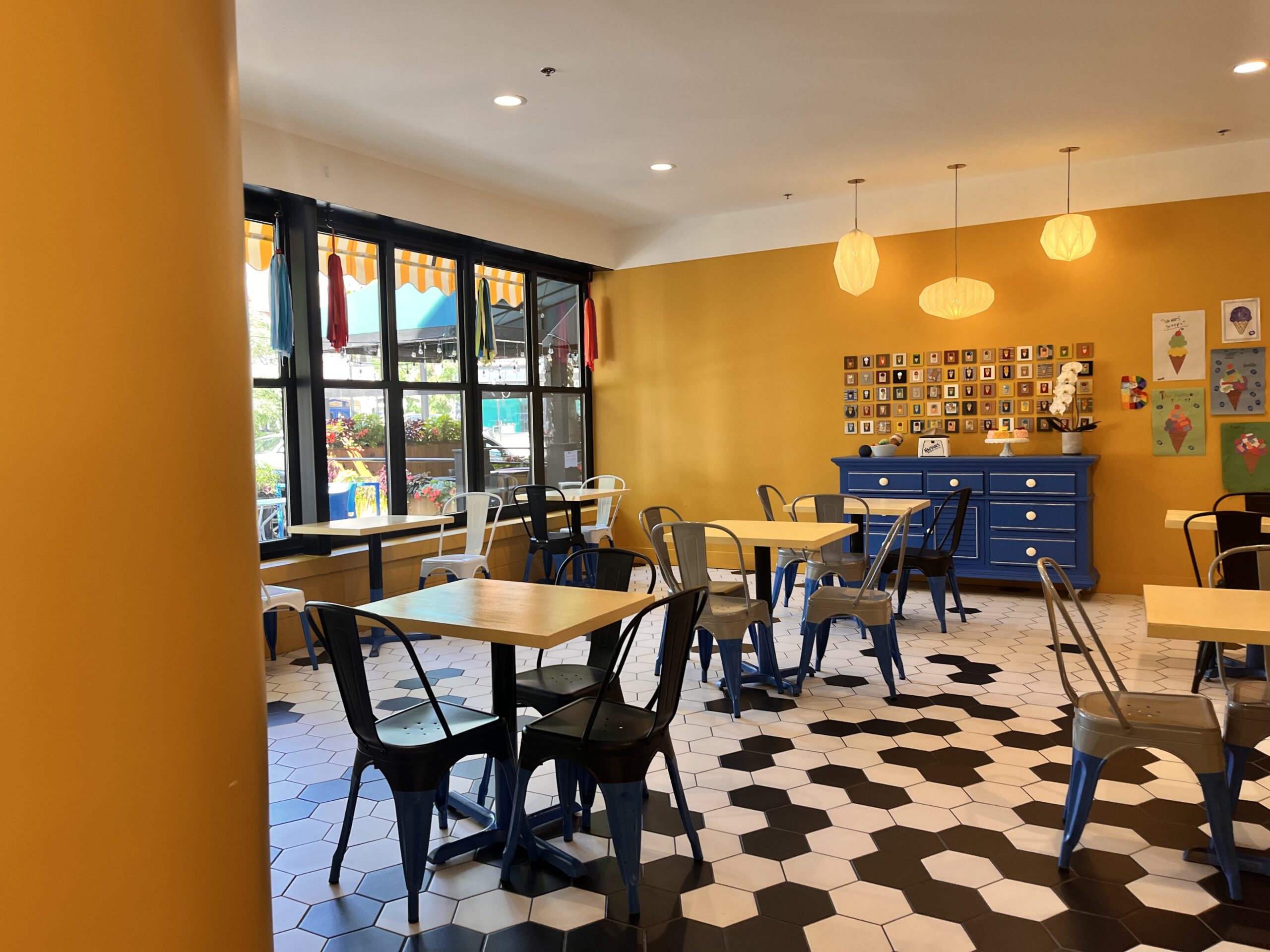 Bartleby's is a cozy space with yellow walls, small tables and black and white hexagon floor tiles.